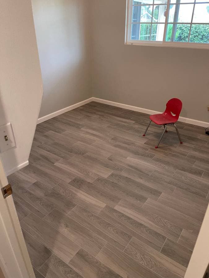 picture of a bedroom renovation with freshly painted walls and gray wood laminate floors
